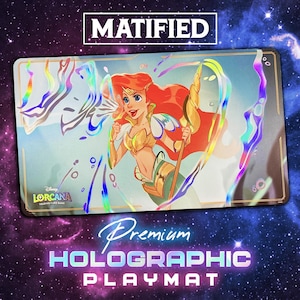 May include: Holographic playmat featuring Ariel from Disney's Lorcana trading card game. The playmat has a gold border and the text "MATIFIED" at the top. The words "Premium Holographic Playmat" are at the bottom.