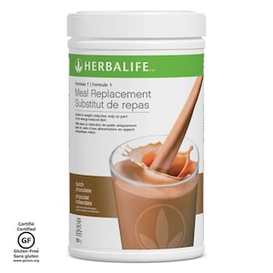 Peut inclure: Un contenant blanc de substitut de repas Herbalife Formula 1 avec une bande verte. Un verre de milkshake au chocolat hollandais avec une éclaboussure est montré. Le contenant a du texte en anglais et en français, et un logo sans gluten.