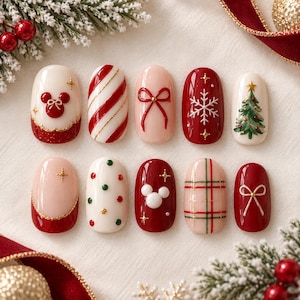 May include: A set of ten press-on nails featuring Christmas designs including red and white candy cane stripes, a green pine tree, white snowflakes, red and white bows, red and green polka dots, plaid patterns, and white Mickey Mouse icons.
