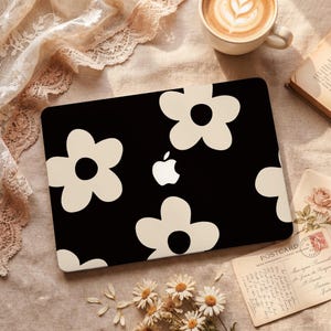 Puede incluir: Una taza de cerámica blanca con un asa negra y el texto "But First, Coffee" en negro y negrita. La taza está sobre una superficie de madera. La taza mide 10 cm de alto.