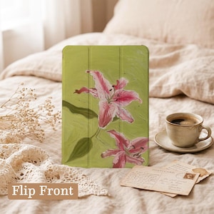 May include: A rectangular tablet case featuring a painted design of two pink lilies on a textured light green background. The case has a tri-fold cover design with visible vertical creases and the text Flip Front printed in the bottom left corner.