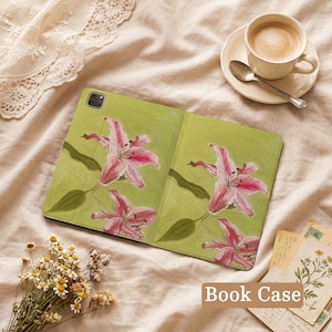 May include: A tablet case featuring a light green background with a painted design of pink lily flowers and green leaves. The case has a rectangular shape with a camera cutout in the top left corner and a textured surface finish.
