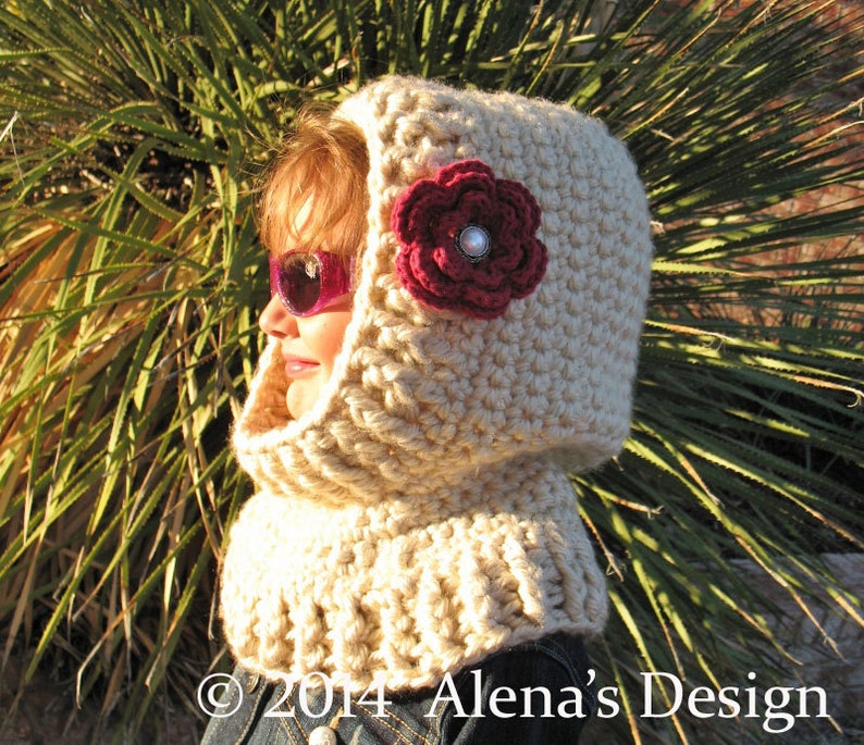 May include: A beige crocheted hood with a cowl neck, adorned with a dark red flower and a pearl-like center. The hood is designed to cover the head and neck, offering warmth and style. The text "&copy; 2014 Alena's Design" is visible at the bottom.