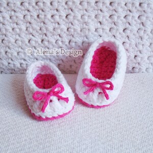 Puede incluir: Un par de zapatos de beb&eacute; de ganchillo blanco con lazos rosas y ribete rosa.