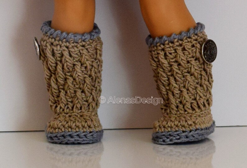 May include: A pair of brown crocheted boots with gray trim and a silver button on each boot.