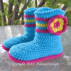 May include: A pair of crocheted slipper boots in turquoise blue with pink and yellow stripes. One boot has a yellow and pink crocheted flower accent.