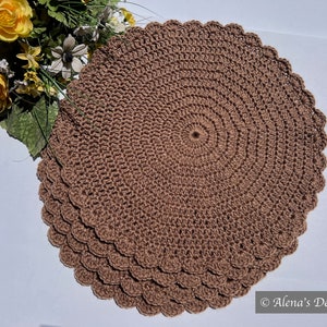 May include: Set of four brown crocheted placemats with scalloped edges. The placemats are made with a circular pattern.