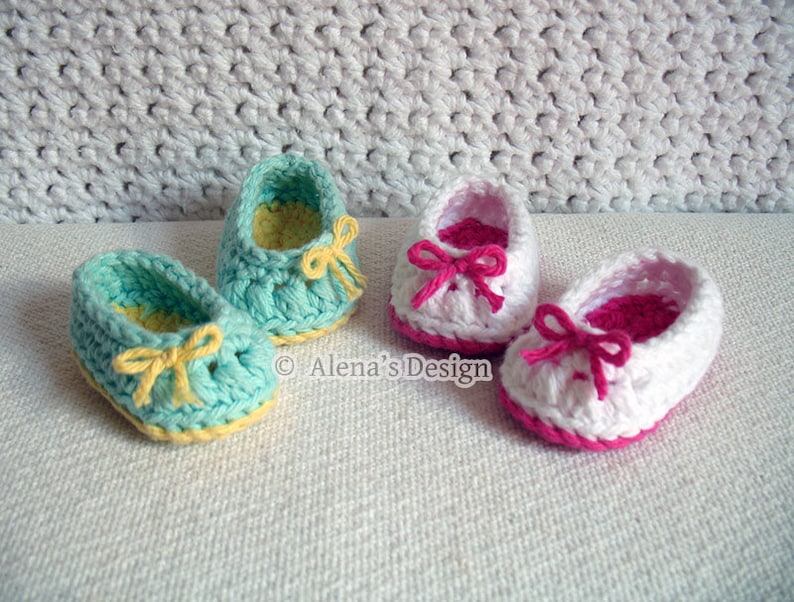 Puede incluir: Dos pares de zapatos de beb&eacute; tejidos a crochet. Un par es azul claro con lazos amarillos y el otro par es blanco con lazos rosas. &copy; Alena's Design