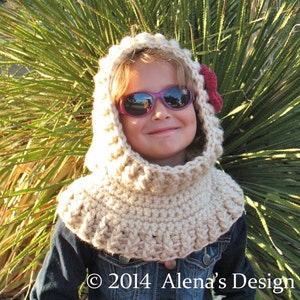 May include: A beige crocheted hood with a red flower accent. The hood is worn over a denim jacket. The image includes the text "&copy; 2014 Alena's Design".