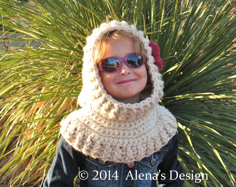May include: A beige crocheted hood with a red flower accent. The hood is worn over a denim jacket. The image includes the text "&copy; 2014 Alena's Design".