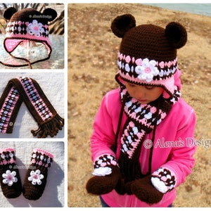 May include: Brown crocheted hat with pink and white accents, matching scarf and mittens. The hat has bear ears and a flower detail. "Alena's Design" is written on the scarf and mittens.
