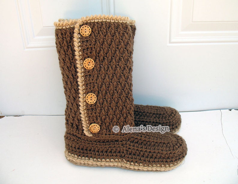 Puede incluir: Pantuflas de crochet marrones con ribete beige y botones de madera. Las pantuflas tienen una punta puntiaguda y una suela de crochet.