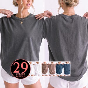 Könnte beinhalten: Ein anthrazitfarbenes T-Shirt mit Rundhalsausschnitt und lockerer Passform, das von vorne und hinten zu sehen ist. Eine kreisförmige Grafik in der unteren linken Ecke zeigt den Text 29 COLORS BUNDLE mit verschiedenen T-Shirt-Farben in Miniatur.