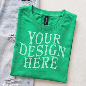 May include: A bright green short-sleeved t-shirt with a crew neckline and a black Gildan brand label at the collar. The front of the shirt features the white distressed-style text that reads YOUR DESIGN HERE in a bold, capitalized font.