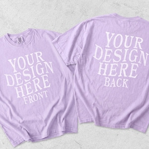 May include: Two light purple short-sleeve t-shirts displayed together. The left shirt features white text reading YOUR DESIGN HERE FRONT. The right shirt features white text reading YOUR DESIGN HERE BACK. Both shirts have a crew neckline.