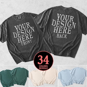 Puede incluir: Dos camisetas gris carbón con el texto "YOUR DESIGN HERE" impreso en la parte delantera y trasera. La imagen también muestra una variedad de colores de camisetas, incluyendo verde, crema y azul claro. Un gráfico circular indica un paquete de 34 colores.