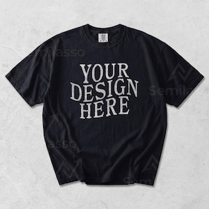 May include: Black t-shirt with the text "YOUR DESIGN HERE" in a distressed white font. The shirt has short sleeves and a crew neck. The shirt is a solid black color.