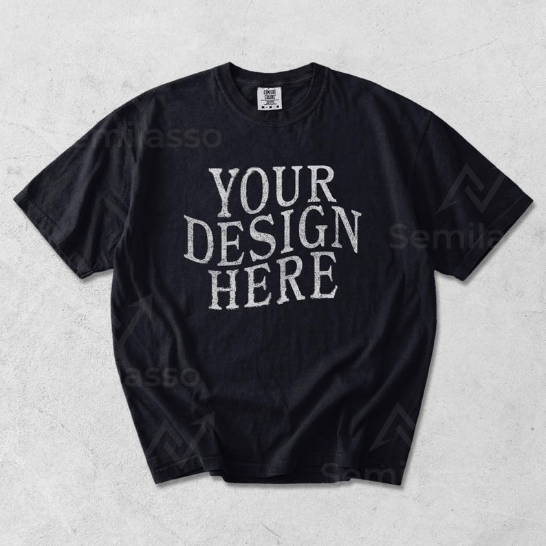 May include: Black t-shirt with the text "YOUR DESIGN HERE" in a distressed white font. The shirt has short sleeves and a crew neck. The shirt is a solid black color.