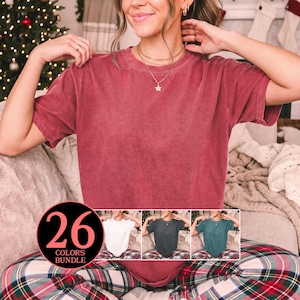 May include: A solid-colored, short-sleeved crewneck t-shirt with a vintage-style washed finish. The shirt is shown in a deep red hue, with smaller inset images displaying the same shirt in white, dark gray, and teal, labeled 26 colors bundle.
