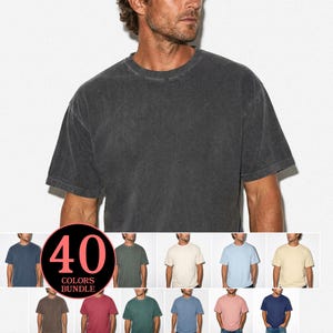 Könnte beinhalten: Ein dunkelgraues T-Shirt mit kurzen Ärmeln und Rundhalsausschnitt. Das Bild zeigt eine Person, die das Shirt trägt, mit einer Vielzahl anderer Farben darunter. Eine kreisförmige Grafik zeigt "40 COLORS BUNDLE".