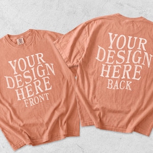 May include: Two coral-colored short-sleeve t-shirts displayed together. The left shirt features white text reading YOUR DESIGN HERE FRONT. The right shirt displays white text reading YOUR DESIGN HERE BACK. Both shirts have a crew neckline.