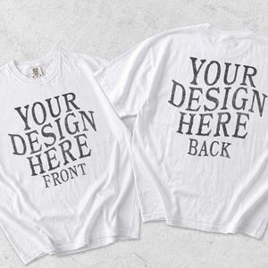 May include: Two white short-sleeve t-shirts displayed side by side. The left shirt features the black text YOUR DESIGN HERE FRONT. The right shirt features the black text YOUR DESIGN HERE BACK. Both shirts have a crew neckline and a standard fit.