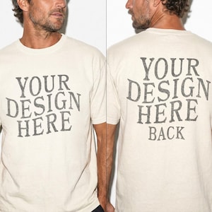 May include: Cream-colored t-shirt with the text "YOUR DESIGN HERE" printed on the front and back. The back of the shirt also includes the word "BACK" below the main text. The text is in a distressed, vintage-style font.