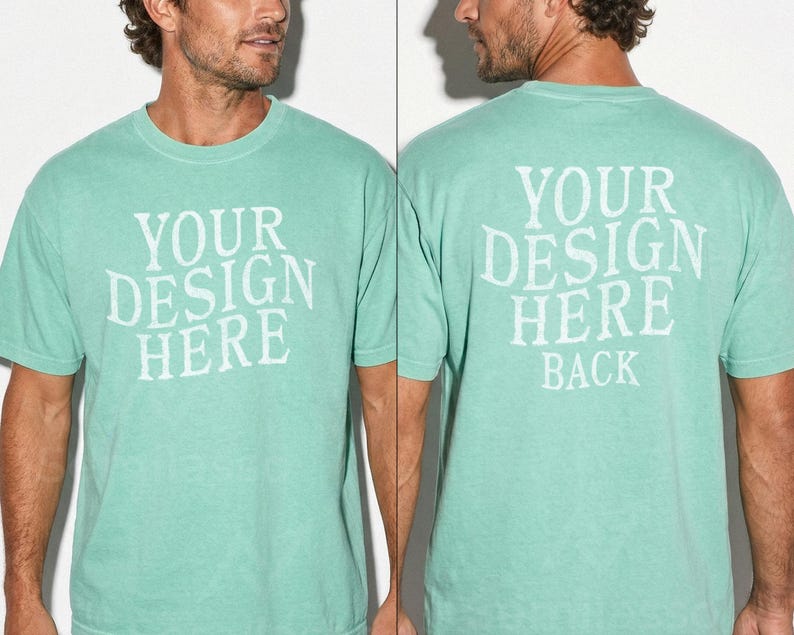 May include: A seafoam green t-shirt with the text "YOUR DESIGN HERE" on the front and "YOUR DESIGN HERE BACK" on the back. The shirt is short-sleeved and has a crew neck.