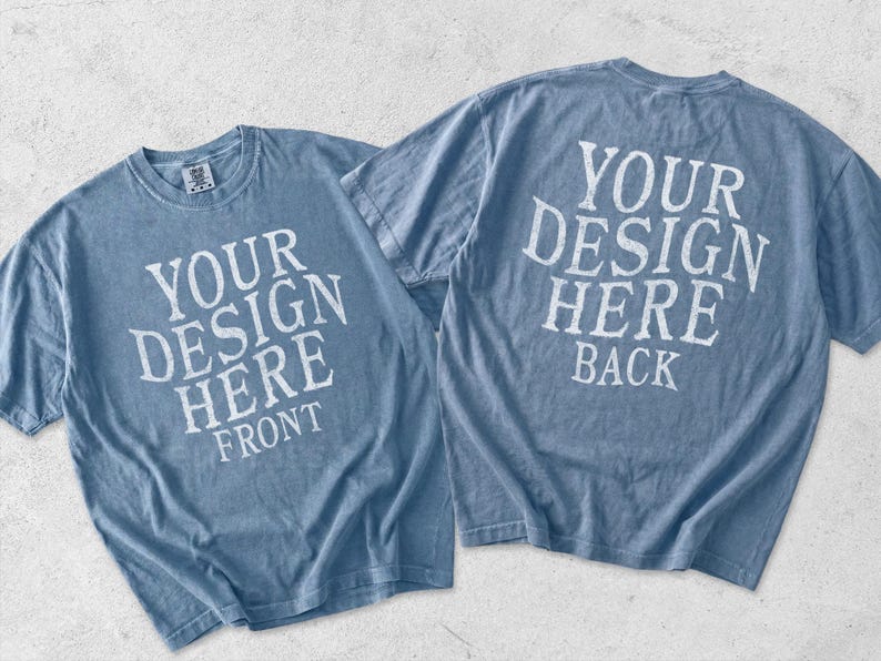 May include: Two blue short-sleeve t-shirts displayed together. The left shirt features white text reading YOUR DESIGN HERE FRONT. The right shirt features white text reading YOUR DESIGN HERE BACK. Both shirts have a crew neckline and a casual fit.