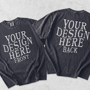 May include: Two charcoal gray short-sleeve t-shirts displayed side by side. The left shirt features the white text YOUR DESIGN HERE FRONT. The right shirt features the white text YOUR DESIGN HERE BACK. Both shirts have a crew neckline and a faded finish.
