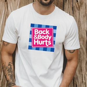 May include: White t-shirt with a square graphic that reads "Back & Body Hurts" in pink and white text. The graphic is set against a blue and white checkered background.