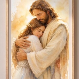 May include: A framed watercolour painting shows two figures in an embrace. One, with long brown hair and a beard, wears a white robe. The other, with long brown hair, is held by the first. The background is a soft, warm yellow, with a wooden frame.