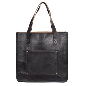 May include: Black leather tote bag with a rectangular shape and a front pocket. The bag has two brown leather handles and brass rivets. The interior is lined with a lighter brown material. A stylish and functional accessory.