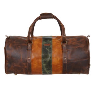 Pu&ograve; includere: Una borsa da viaggio in pelle marrone con finitura invecchiata. La borsa presenta una striscia verticale centrale verde oliva, affiancata da sezioni in pelle marrone chiaro e marrone scuro. Ha un manico superiore e due manici laterali.
