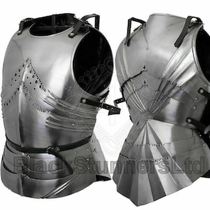 Könnte beinhalten: Zwei polierte Brustpanzer aus Stahl mit schwarzen Lederriemen. Die Rüstung hat eine reflektierende Oberfläche und ist mit geschichteten Platten und dekorativen Kanten versehen. Die Brustpanzer sind wahrscheinlich für historische Nachstellungen oder Ausstellungen gedacht.