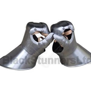 May include: A pair of polished steel gauntlets, designed for medieval armor. The gauntlets feature articulated fingers and a flared cuff. The interior shows leather padding and straps for securing the hands. The overall design is symmetrical and functional.