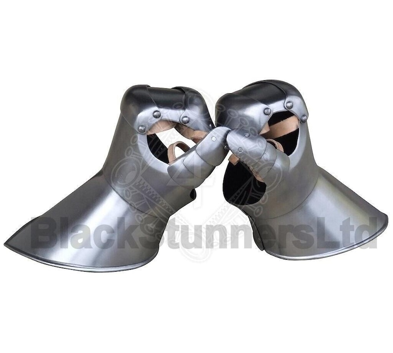 May include: A pair of polished steel gauntlets, designed for medieval armor. The gauntlets feature articulated fingers and a flared cuff. The interior shows leather padding and straps for securing the hands. The overall design is symmetrical and functional.