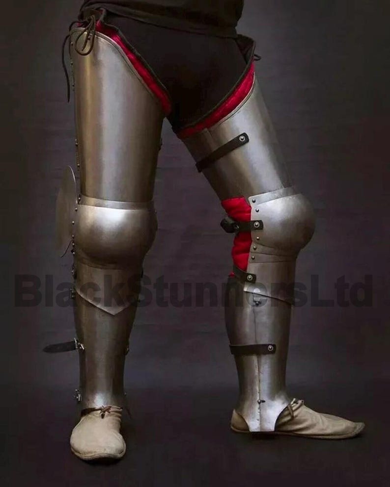 May include: A pair of steel leg armor, featuring articulated plates for knee protection and lower leg coverage. The armor has a polished finish with leather straps and rivets. The interior padding is red. The text "BlackStunnersLtd" is visible.