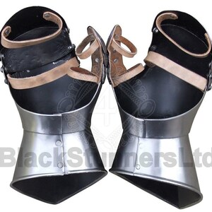 May include: Pair of black and silver gauntlets with leather straps and accents. The gauntlets have a polished metal finish on the lower portion and are designed to protect the hands and wrists. The image shows the gauntlets from a front view.