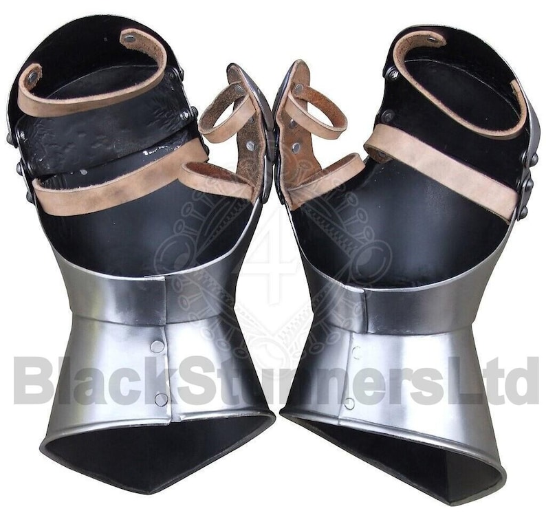 May include: Pair of black and silver gauntlets with leather straps and accents. The gauntlets have a polished metal finish on the lower portion and are designed to protect the hands and wrists. The image shows the gauntlets from a front view.
