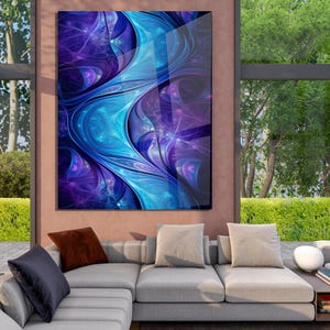 May include: Abstract art print with a dynamic design in blue and purple hues. The artwork has a flowing, fractal-like pattern with a glossy finish. The print is displayed on a wall above a grey sectional sofa, with a view of a green outdoor space.