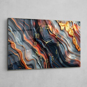 May include: A rectangular wall clock featuring an abstract design of flowing, wavy lines in shades of dark blue, gray, and vibrant orange. The clock face displays gold-colored numerals and thin gold hands set against the marbled pattern.