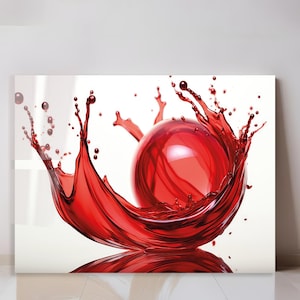 May include: A vibrant, artistic print featuring a red sphere at the center, surrounded by a dynamic splash of red liquid. The artwork is set against a white background, creating a striking visual contrast. The liquid appears to be in motion, adding a sense of energy.