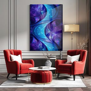 May include: An abstract art print in shades of blue and purple, displayed above two red armchairs with white cushions. A round coffee table and a red ottoman complete the scene. The room has a modern design, with a floor lamp and neutral walls.