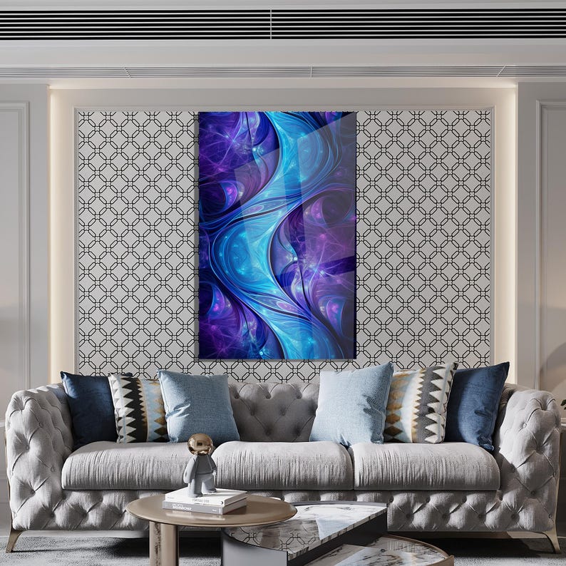 May include: Abstract art print with a dynamic composition of blue and purple hues. The artwork, with a glossy finish, is mounted on a wall above a grey sofa with cushions. The image suggests a modern interior design theme.