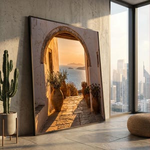 Könnte beinhalten: Ein großes, rechteckiges gerahmtes Wandbild, das einen Steinbogen mit Blick auf ein ruhiges Meer bei Sonnenuntergang zeigt. Die Szene umfasst Terrakottatöpfe mit Grünpflanzen entlang eines Steinwegs, beleuchtet durch warmes Licht.