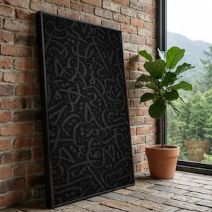 May include: A framed black artwork featuring a repeating pattern of stylized calligraphy. The artwork is leaning against a brick wall, next to a potted plant. The frame is black and the calligraphy is a darker shade of black.