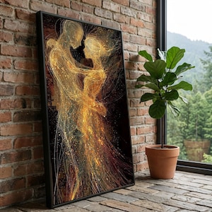 May include: A framed art print depicts a couple embracing, rendered in gold and bronze tones against a black background. The artwork features a flowing, abstract style with a sense of movement and emotion. The print is leaning against a brick wall.