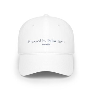 Pode incluir: Boné de beisebol branco com aba curva. Apresenta o texto "Powered by Palm Trees" em azul marinho e "MotionBlue" abaixo. Um acessório clássico para proteção solar.