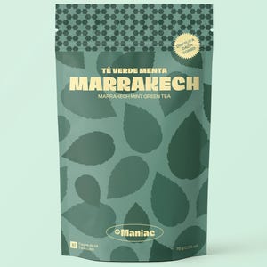 Könnte beinhalten: Ein türkisgrüner Beutel mit Marrakech Mint Green Tea. Die Tasche zeigt ein Muster aus Blättern und den Text "Té Verde Menta Marrakech" in großen, fetten Buchstaben. Die Tasche enthält auch den Markennamen "Maniac" und das Gewicht des Tees, 75g.